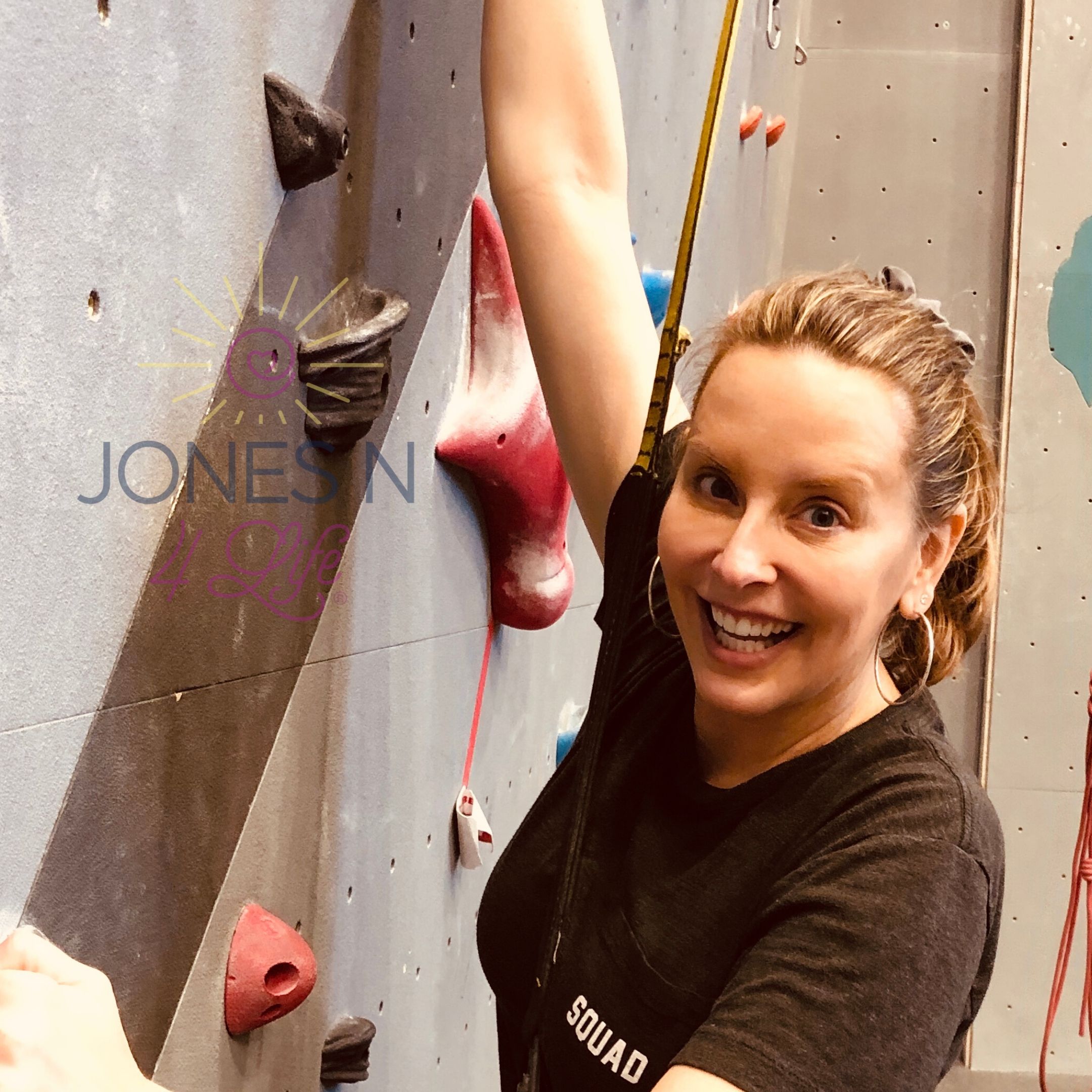 Neile gets ready to rock climb at an indoor rock climbing facility.